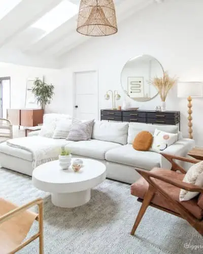 Modern living room with sofa, chairs, and decorative items.