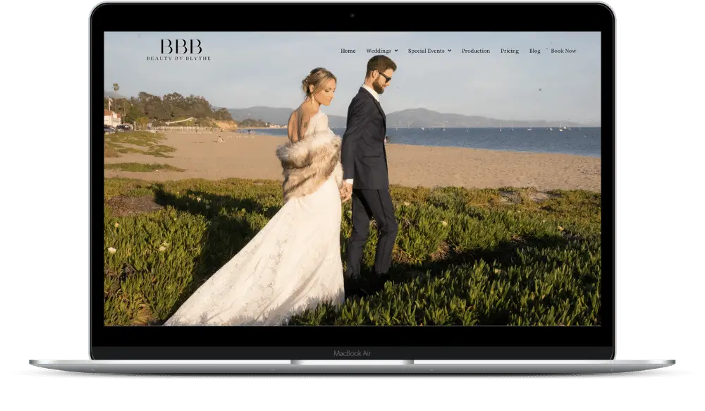 Bride and groom walking on a beach.