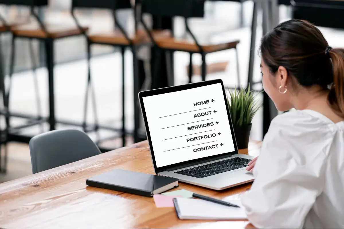 Woman browsing website menu on laptop